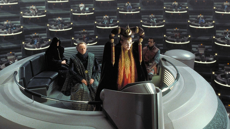 Queen Padme Amidala (Natalie Portman) addresses the Galactic Senate with Senator Palpatine (Ian McDiarmid) in Star Wars: Episode I — The Phantom Menace