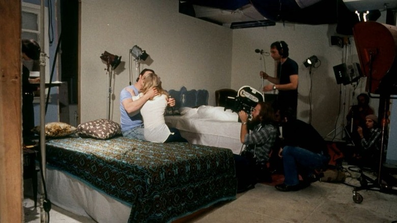 The film crew of Snuff 1976 filming a man and woman kissing on a bed